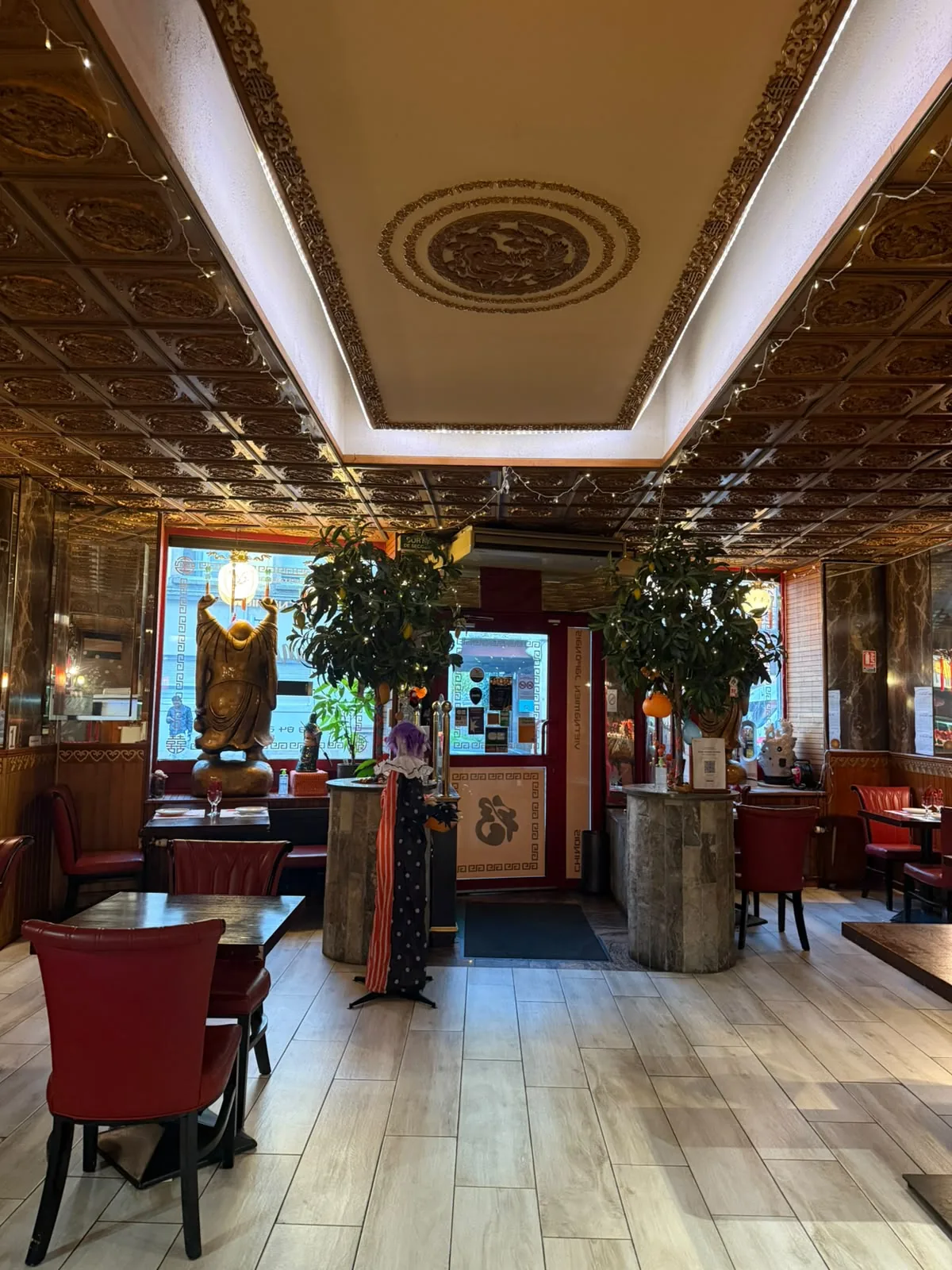 Salle du restaurant Le Shang'Hai à Belfort, décor asiatique en bois sculpté et fauteuils rouges